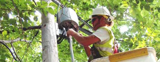 Photo of worker adjusting a wireless access point.